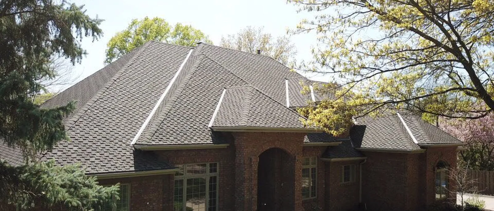 Clean gutter lines along the eaves of a completed brick home