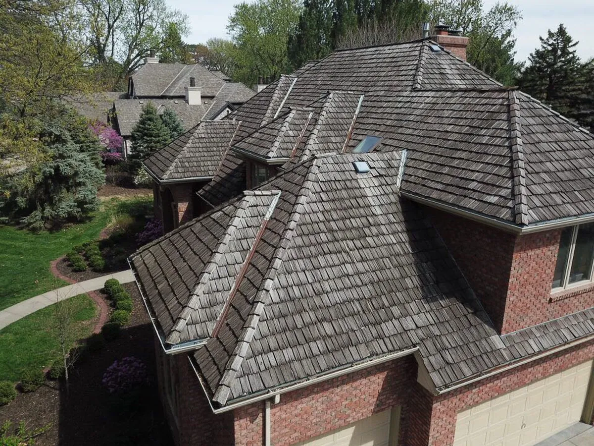 Aging wood shake roof on a brick two-story home