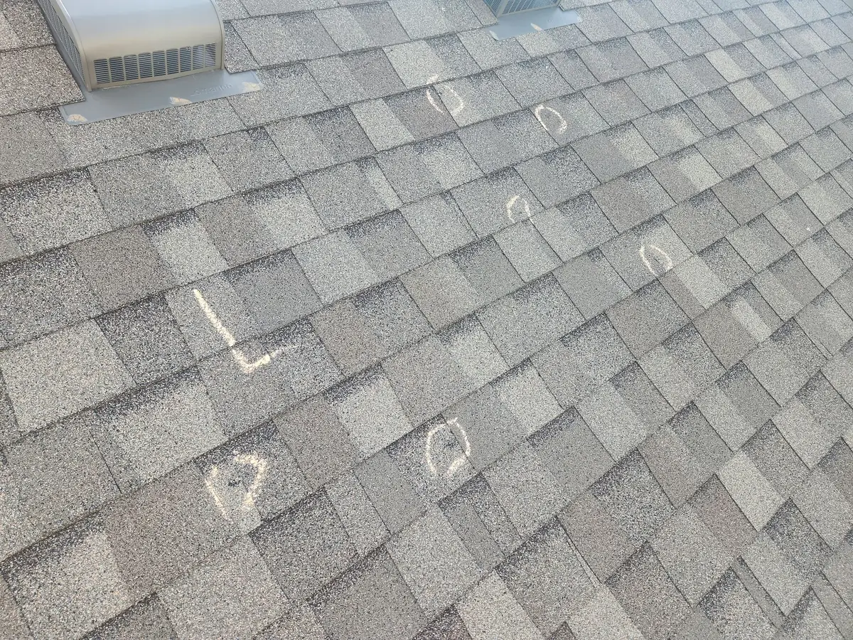 Hail strikes chalk-marked on a shingle roof during a documented inspection